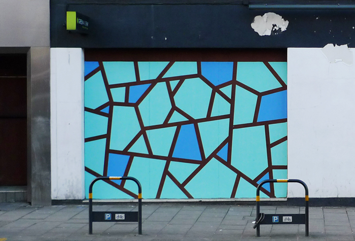 Painted shutter with a blue and teal geometric pattern