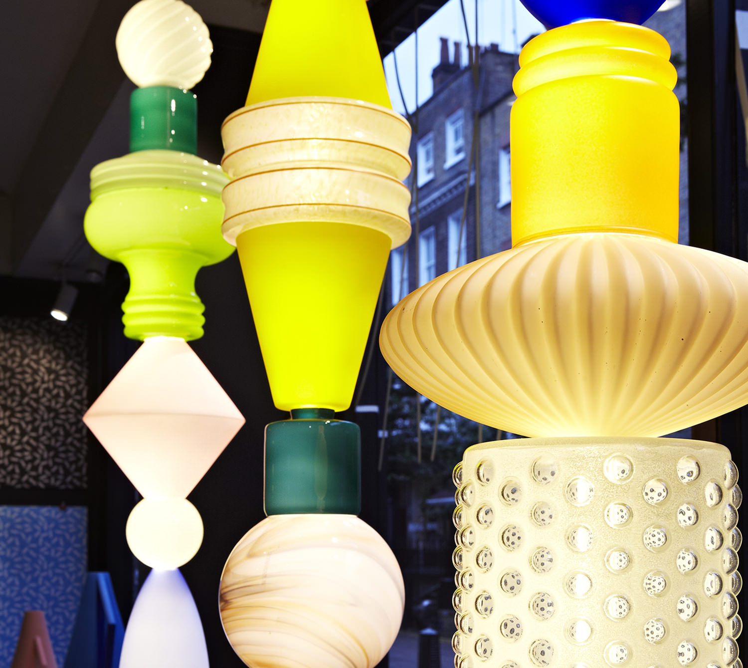 Stacked glass totem lights glowing in yellow, green and white