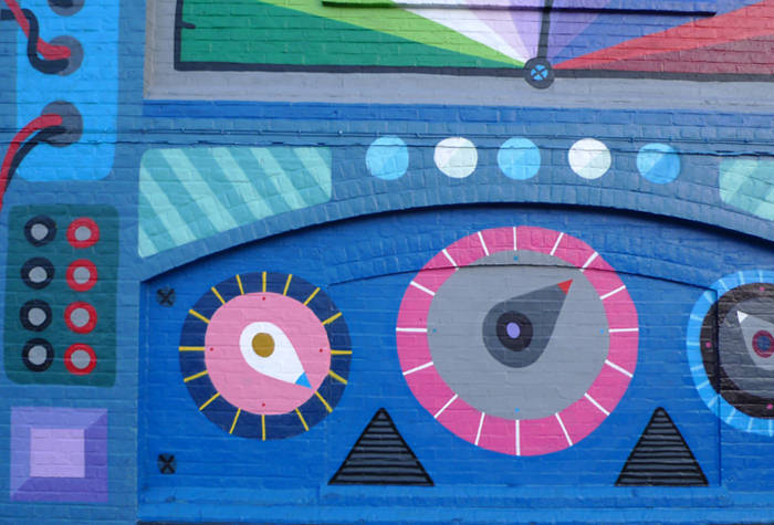 Wall painting with dials and speaker shapes in blue and pink