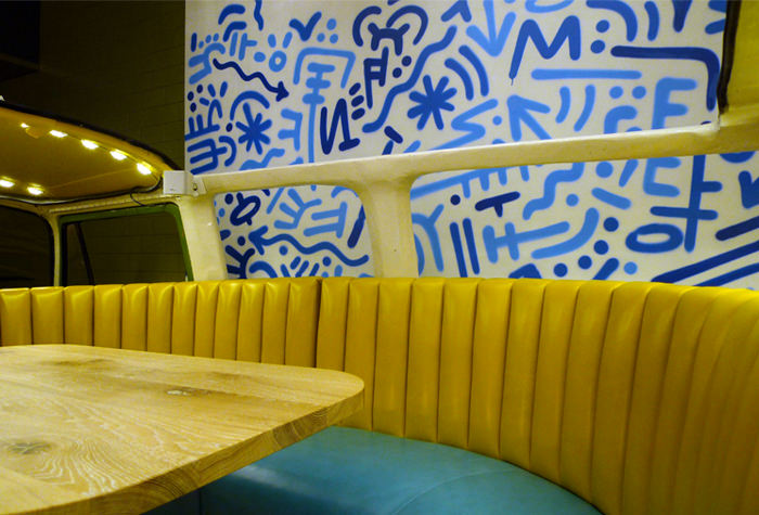 Yellow booth seating against a blue patterned wall